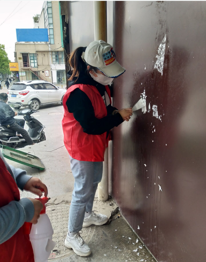 社区志愿者清理墙面小广告作者:卫星 秦龙 苏强